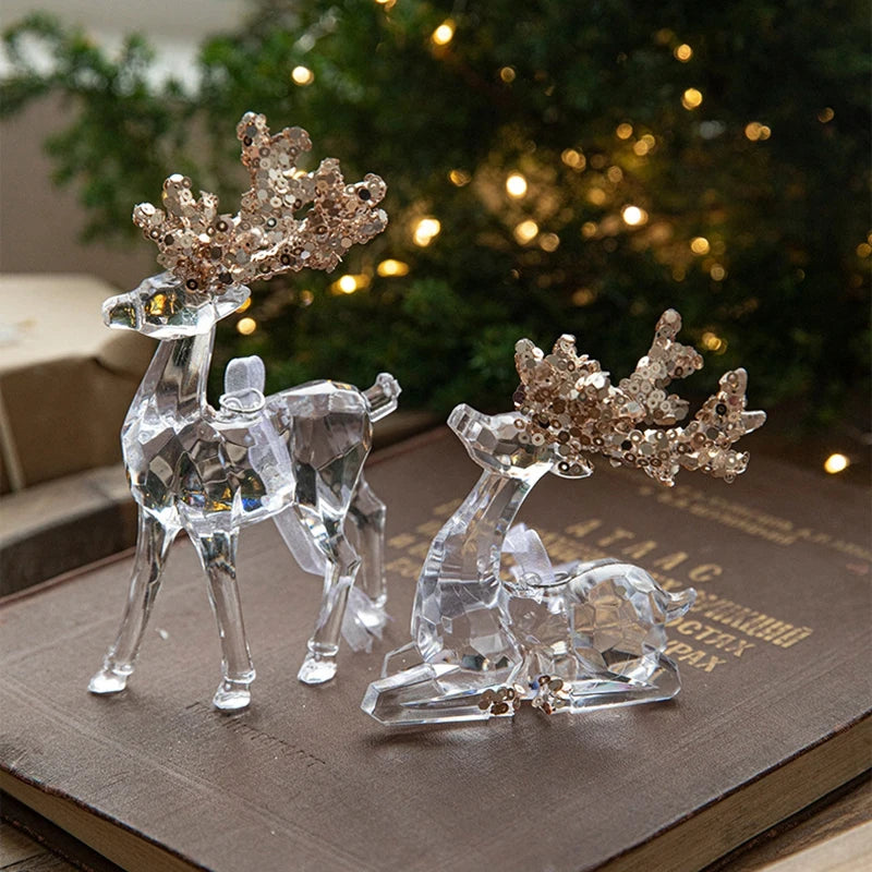 Crystal reindeer figurines with decorative antlers on a book with a blurred Christmas tree in the background.