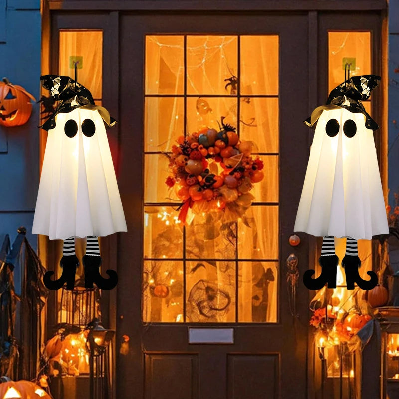 Halloween decorations on a door with ghosts, pumpkins, and a wreath.